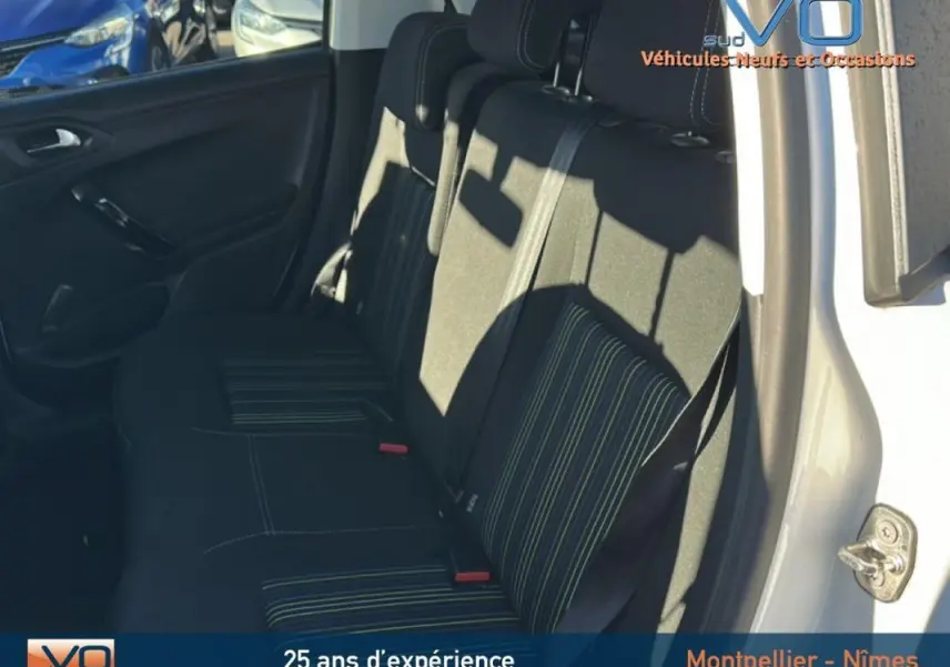 Vue intérieure côté droit des sièges arrière noirs à rayures vertes d'une Peugeot 208 blanche de 2015.