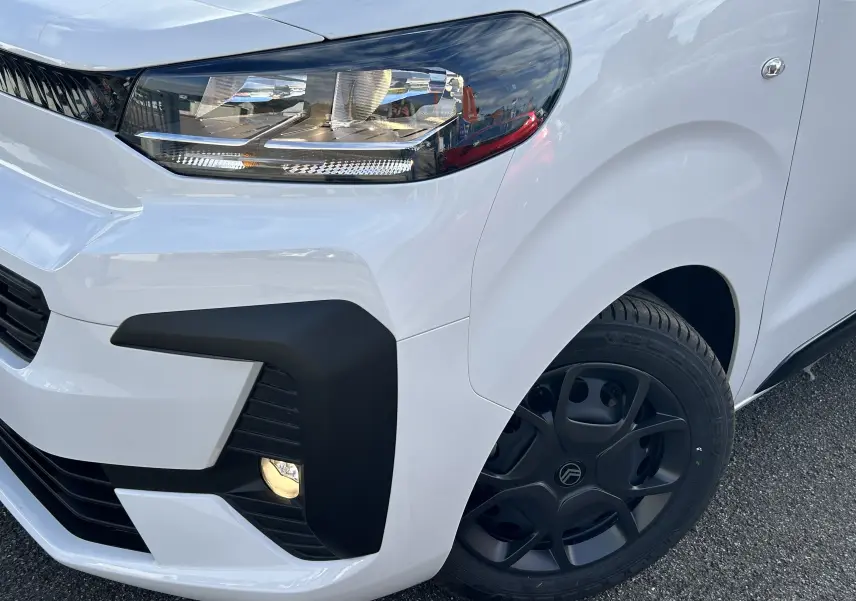 Gros plan sur l’avant droit blanc du Citroën Jumpy 2025 avec phare moderne et jante noire distinctive.