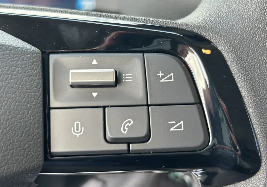 Gros plan sur les commandes au volant côté gauche du Citroën Jumpy blanc, boutons de volume et téléphone visibles.