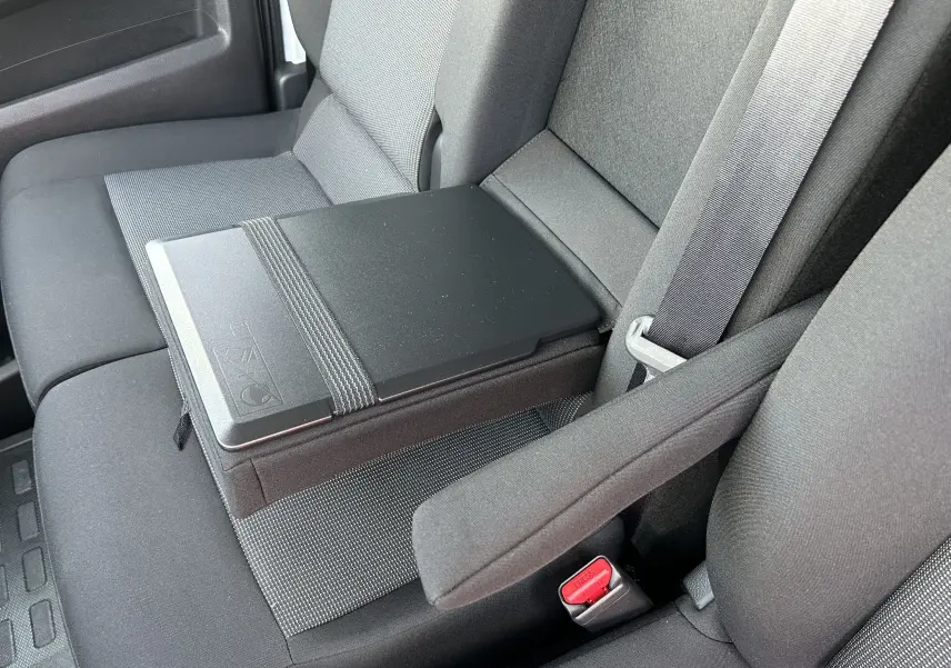 Vue rapprochée de la banquette avant grise du Citroën Jumpy avec accoudoir central et ceinture de sécurité visible.