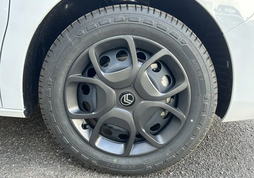 Gros plan sur la roue avant droite du Citroën Jumpy blanc, avec jante alliage grise au design moderne.