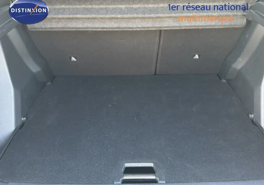 Coffre ouvert d'un Peugeot 2008 gris platinium, vue de l'intérieur montrant l'espace de chargement vide.