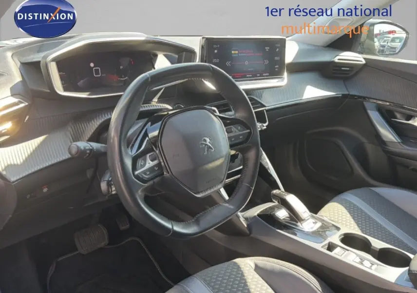 Vue intérieure du poste de conduite de la Peugeot 2008 gris platinium, avec volant compact et écran tactile central.
