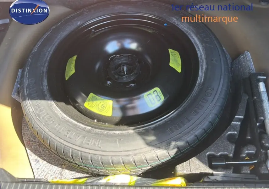 Vue rapprochée de la roue de secours noire dans le coffre d'une Peugeot 2008 gris platinium de 2020.