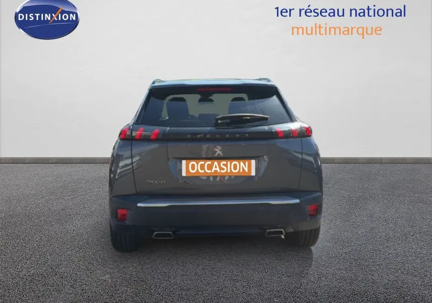 Vue arrière d'un Peugeot 2008 gris platinium avec feux LED et double sortie d'échappement visible.