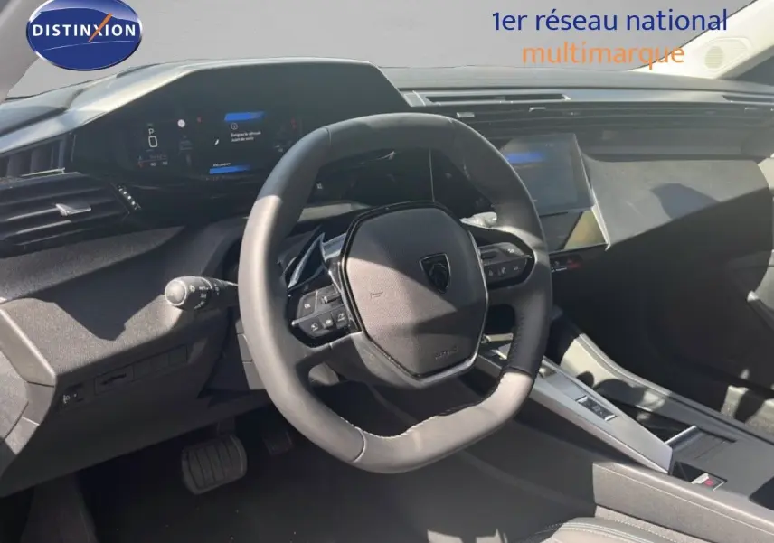 Intérieur de la Peugeot 308 Hybrid 145ch 2025, vue du poste de conduite avec volant cuir noir et tableau de bord digital.