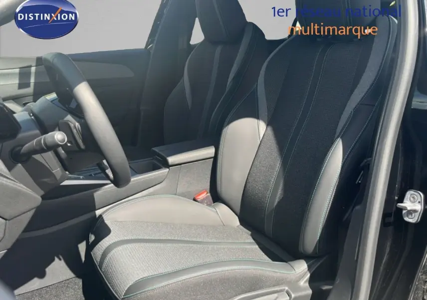 Vue intérieure côté conducteur de la Peugeot 308 Hybrid 145ch Allure 2025, sièges tissu et cuir gris noir, porte ouverte.