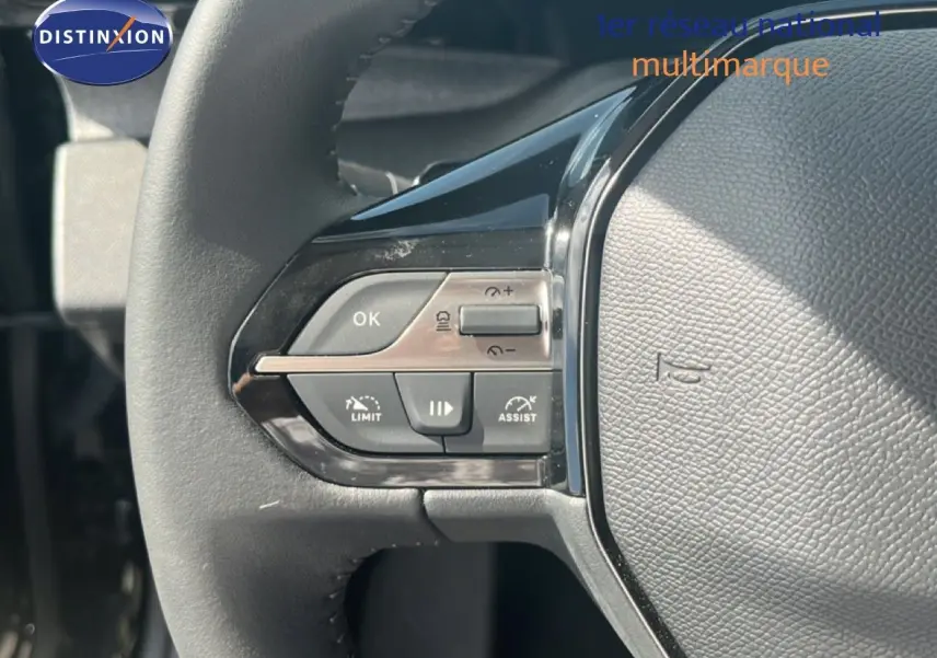 Gros plan sur les commandes à gauche du volant cuir noir de la Peugeot 308 Hybrid 145ch 2025.
