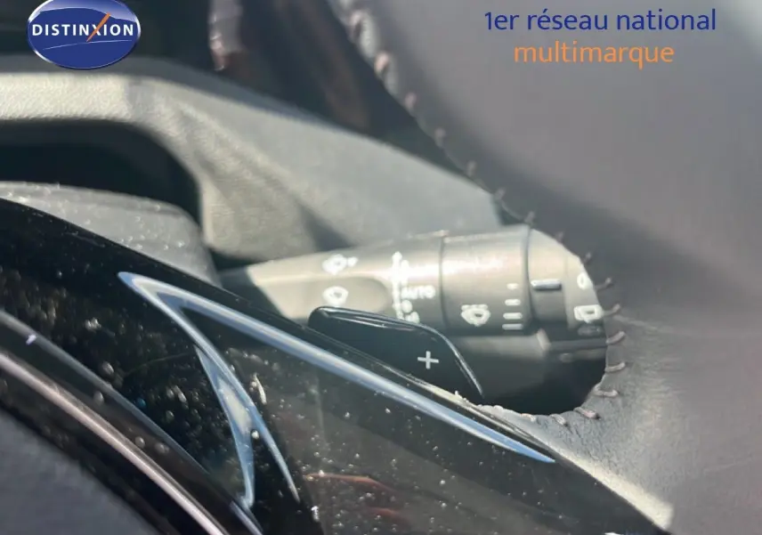 Gros plan sur la palette de changement de vitesse côté droit du volant en cuir noir de la Peugeot 308 Hybrid 2025.