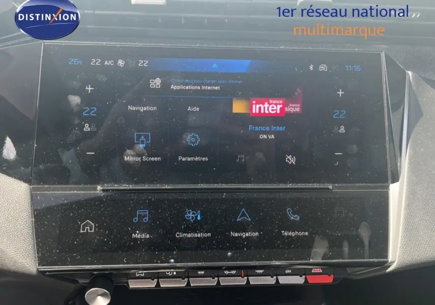 Écran tactile central de la Peugeot 308 Hybrid 2025, affichant la radio France Inter et les commandes de climatisation.