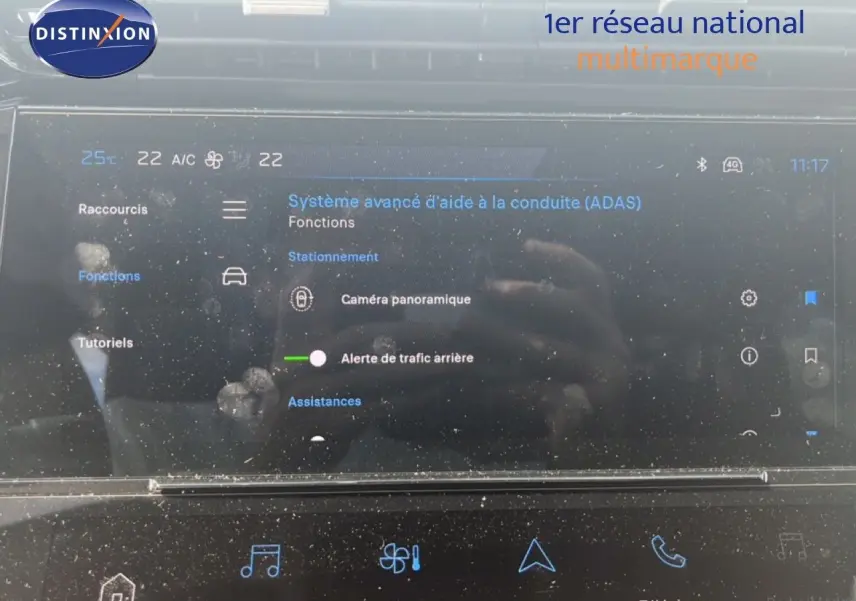 Écran tactile intérieur de la Peugeot 308 Hybrid 145ch Allure 2025 affichant les aides à la conduite, avec reflets et traces visibles.