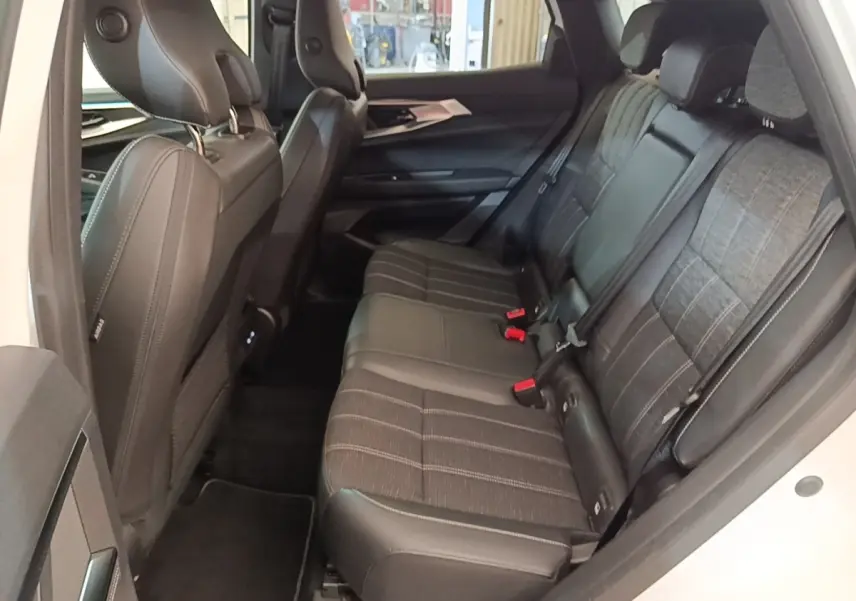 Vue intérieure côté droit montrant la banquette arrière noire avec assise fractionnée du Renault Austral blanc 2023.