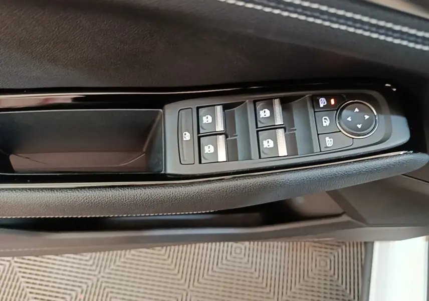 Détail des commandes de lève-vitres et rétroviseurs sur la porte côté conducteur du Renault Austral blanc 2023.