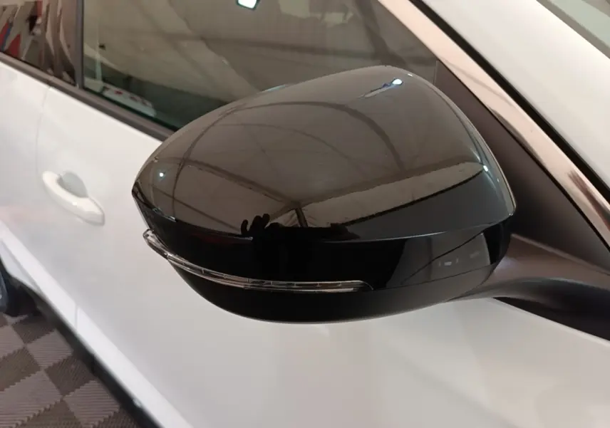 Rétroviseur noir en gros plan côté gauche sur Renault Austral blanc, avec clignotant intégré visible.