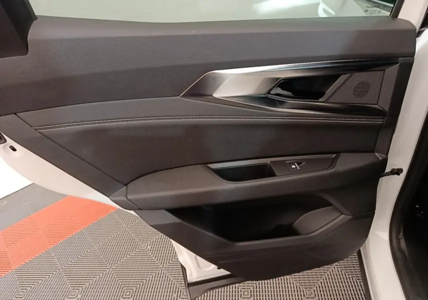 Vue intérieure du panneau de porte arrière droite noire avec insert argenté sur Renault Austral blanc 2023.