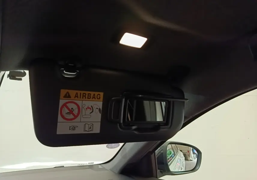 Vue intérieure du pare-soleil côté conducteur avec miroir et éclairage allumé sur Renault Austral blanc 2023.