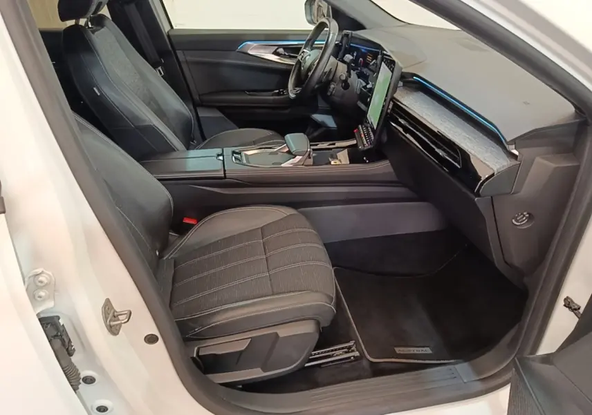 Vue intérieure côté passager avant du Renault Austral blanc, avec sièges noirs et écran tactile vertical lumineux.