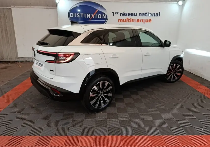 Vue 3/4 arrière droite du Renault Austral blanc 2023 avec feux LED et toit noir contrastant dans un showroom.