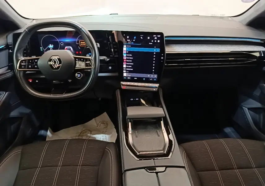 Intérieur Renault Austral 2023 vu de face, tableau de bord noir avec écran tactile vertical et volant cuir multifonctions.