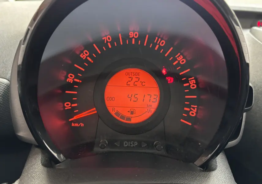 Gros plan sur le tableau de bord de la Toyota Aygo 1.0 VVT-i x-black 2020, affichage rouge avec vitesse et température extérieure.