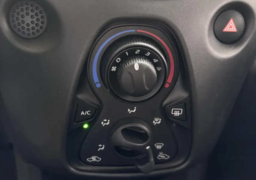 Gros plan sur les commandes de climatisation noire du tableau de bord de la Toyota Aygo gris foncé 2020.