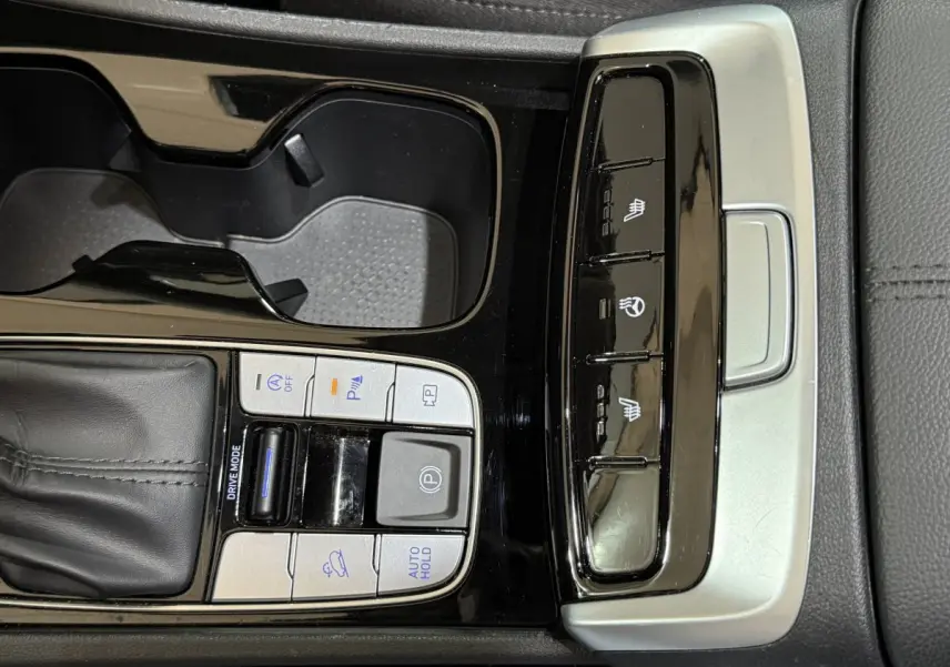 Gros plan sur la console centrale noire du Hyundai Tucson 2021 avec commandes de conduite et sièges chauffants.