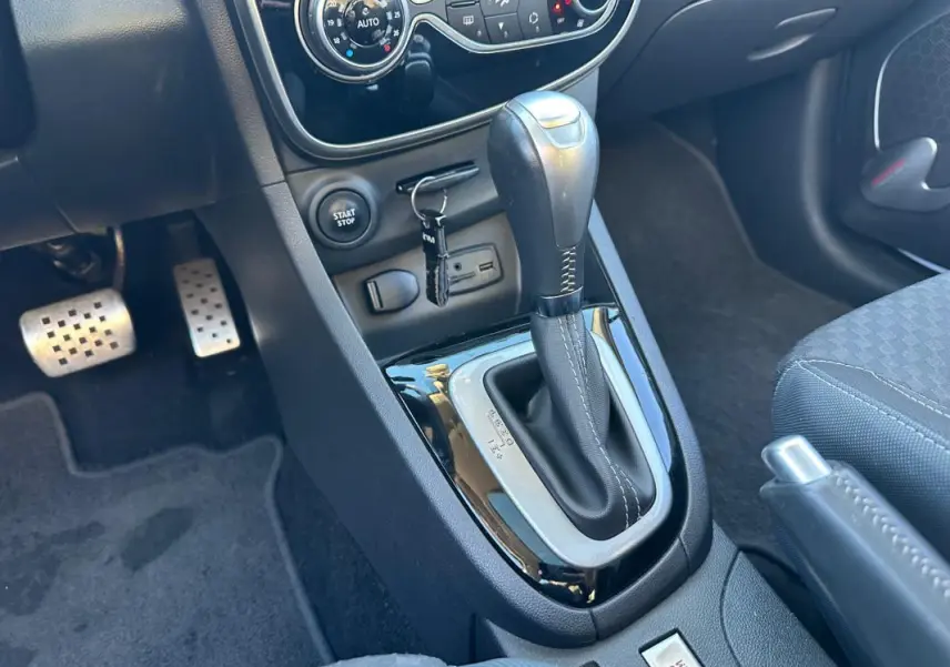 Gros plan sur la console centrale de la Renault Clio IV TCe 120 GT EDC blanche, montrant levier de vitesse automatique et commandes.