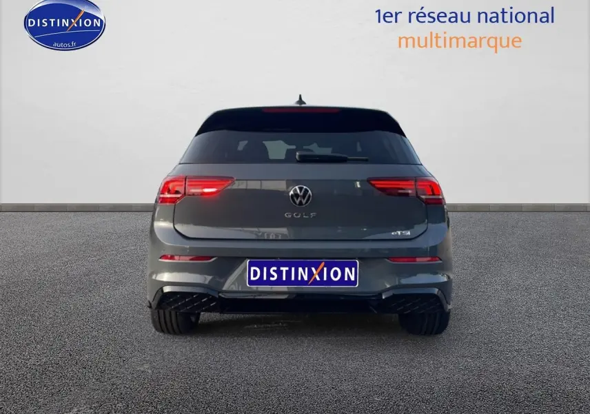 Vue arrière d'une Volkswagen Golf gris métallisé avec feux LED et logo distinctif eTSI sur fond neutre.