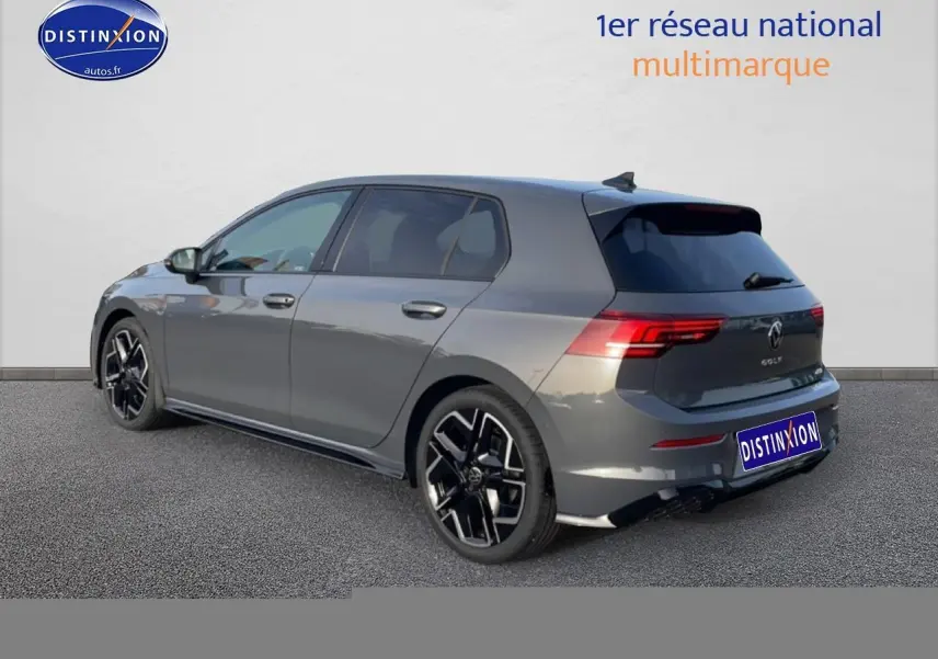 Vue 3/4 arrière droite d'une Volkswagen Golf gris métallisé avec jantes alu noires et feux arrière LED allumés.