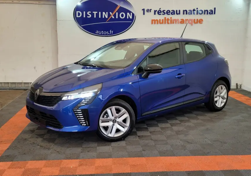 Renault Clio Evolution Blue dCi 100 2025 bleu, vue 3/4 avant droit avec phares LED allumés en intérieur showroom