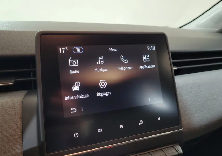 Écran tactile central de la Renault Clio 2025 affichant le menu principal avec options radio, musique et téléphone.