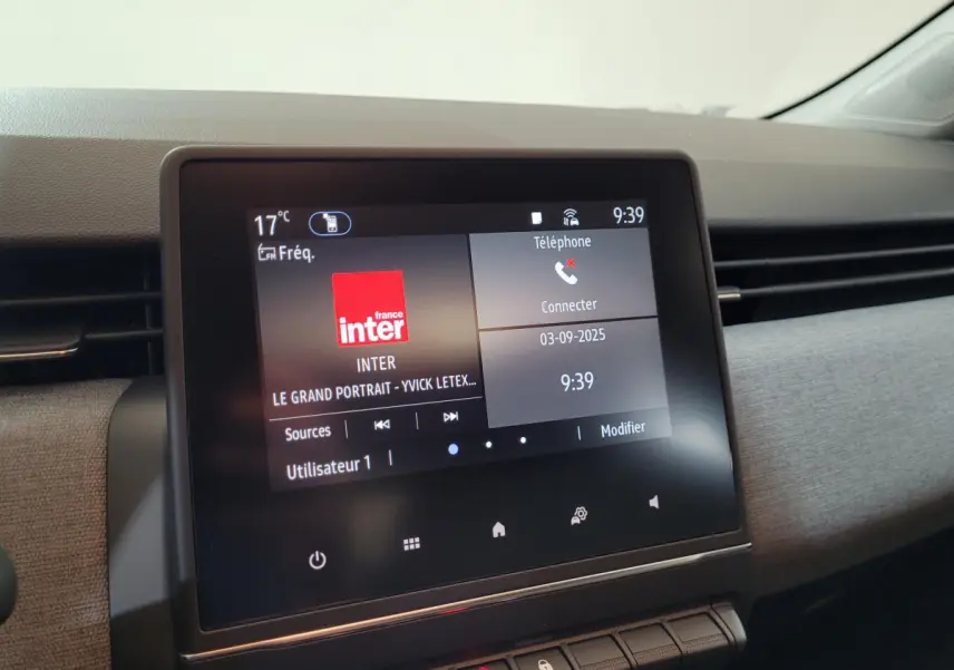 Écran tactile central allumé affichant radio et téléphone dans l’habitacle d’une Renault Clio bleu Evolution 2025