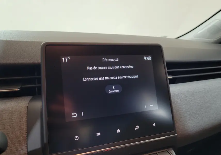 Écran tactile central du tableau de bord de la Renault Clio bleu 2025 affichant un message de connexion Bluetooth.