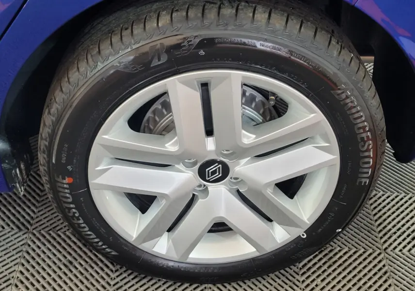 Gros plan sur la roue avant droite d'une Renault Clio bleu 2025 avec pneu Bridgestone visible.