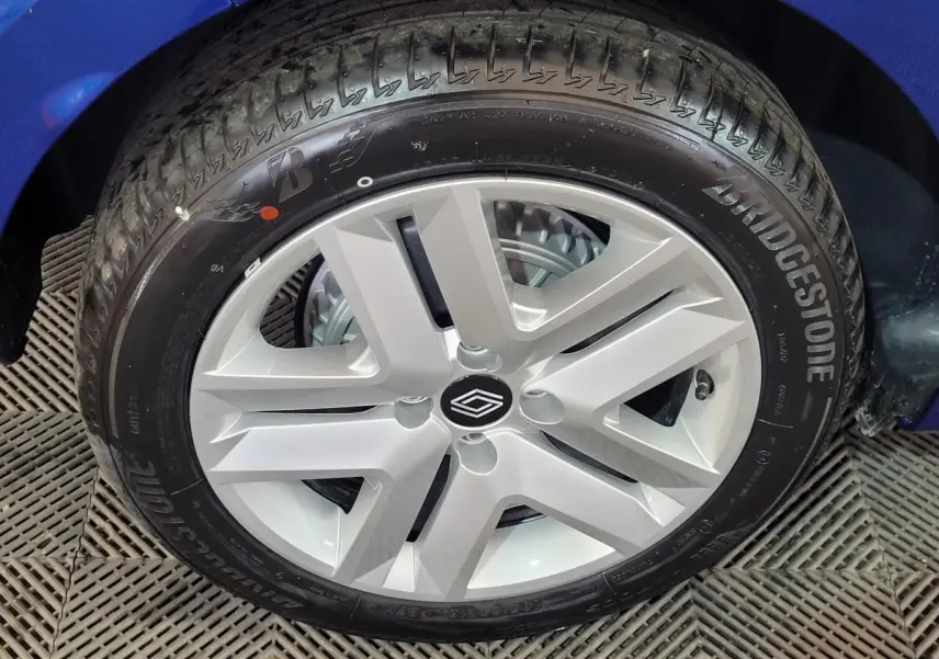 Gros plan sur la roue avant droite d'une Renault Clio bleu 2025 avec jante argentée et pneu Bridgestone.