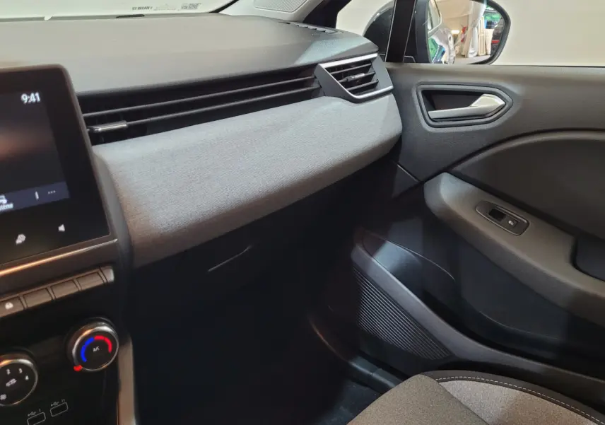 Intérieur de la Renault Clio Evolution Blue dCi 100 2025, vue côté passager avec tableau de bord gris clair et écran tactile.