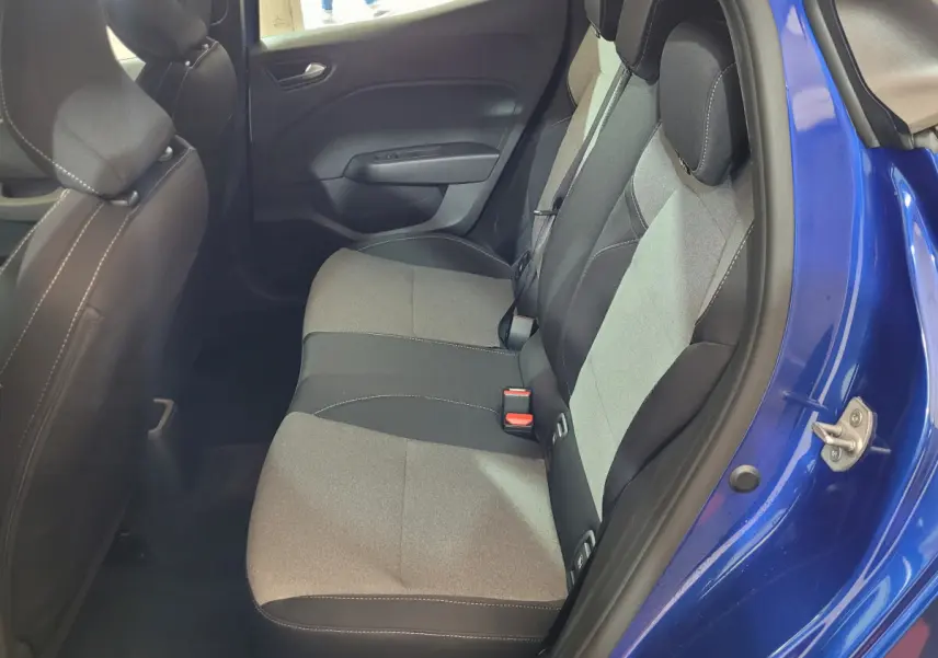 Vue intérieure côté droit sur la banquette arrière grise et noire d'une Renault Clio bleu 2025 avec porte ouverte.