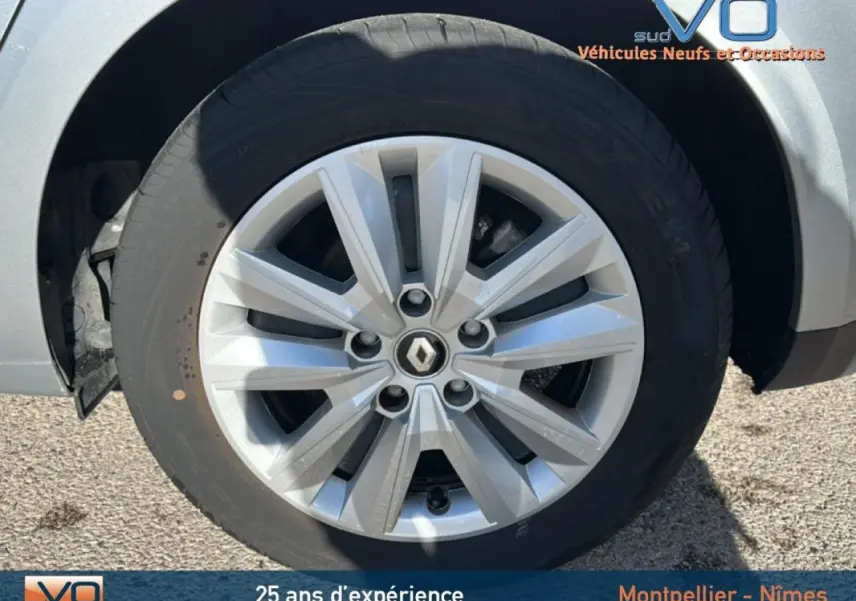 Gros plan sur la jante 16 pouces argentée avec logo Renault d'une Renault Mégane IV gris clair, côté avant droit.