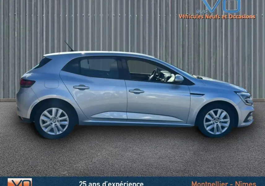 Profil latéral droit d'une Renault Mégane IV gris clair, berline compacte avec jantes 16 pouces et lignes épurées.