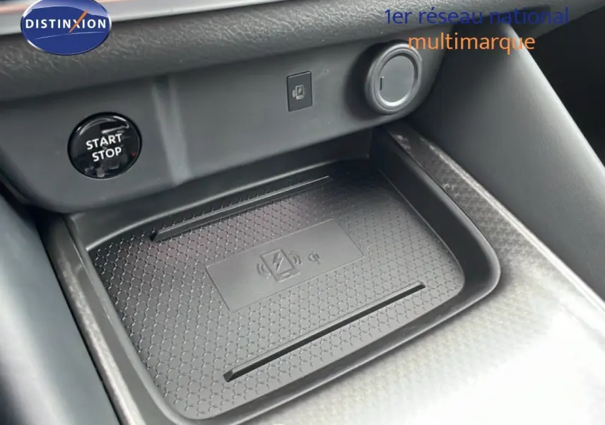 Détail de la console centrale du Nissan Qashqai 2025 avec surface de charge sans fil et bouton start/stop noir.