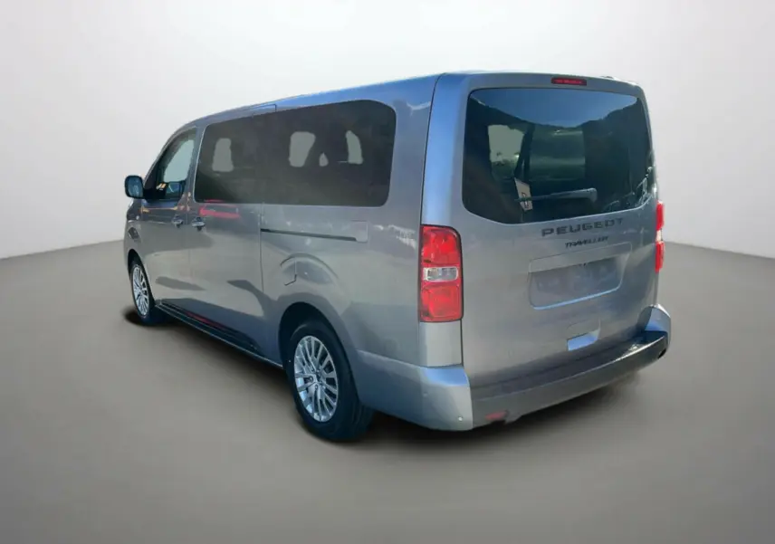Vue 3/4 arrière droite d'un Peugeot Traveller gris acier avec vitres surteintées et deux portes coulissantes.