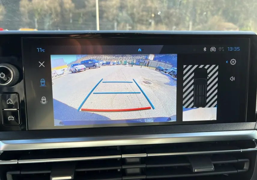 Écran central du Peugeot Traveller 2025 montrant la caméra de recul avec vue arrière et top-down du véhicule.