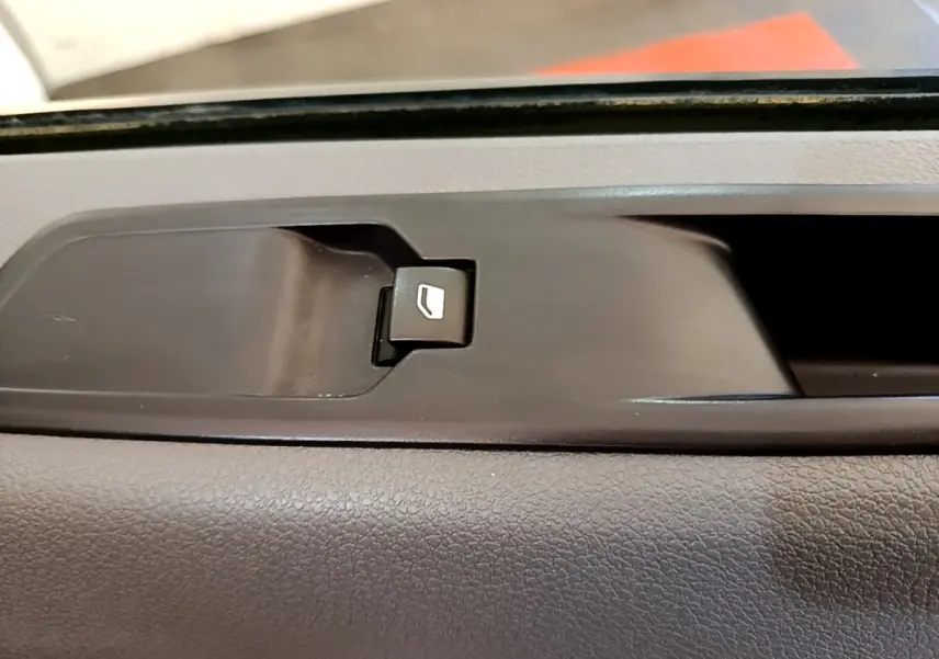 Gros plan sur le bouton de commande de la vitre côté intérieur d'une Peugeot Traveller blanc de 2018.