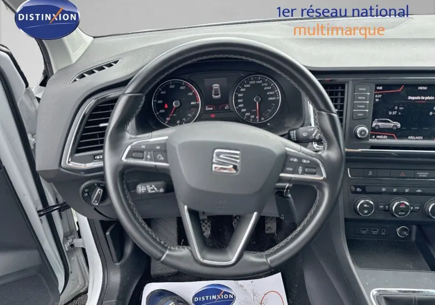 Vue intérieure centrée sur le volant du SEAT Ateca blanc Nevada 2018 avec tableau de bord et écran multimédia visible.