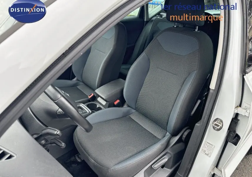 Vue intérieure côté conducteur du SEAT ATECA blanc Nevada 2018, mettant en valeur le siège avant en tissu gris.