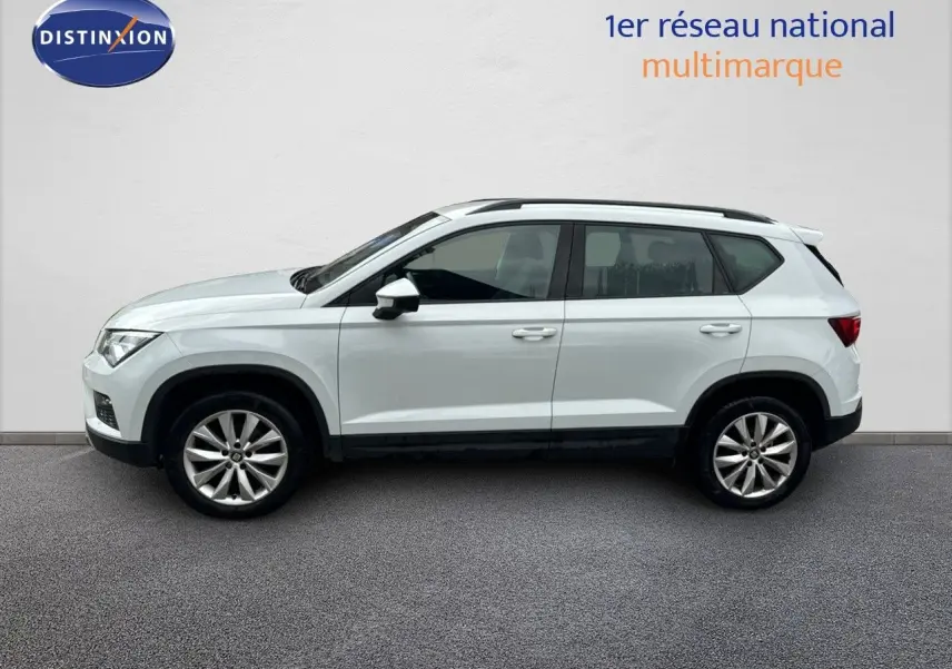 Profil côté gauche d'un SUV SEAT Ateca blanc Nevada 2018, version Style Plus avec jantes alliage et toit noir.