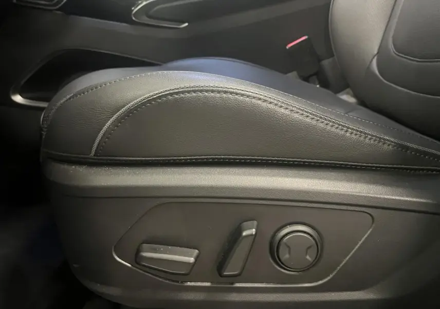 Gros plan sur les commandes de réglage électrique du siège conducteur en cuir noir du Hyundai Tucson 2023.