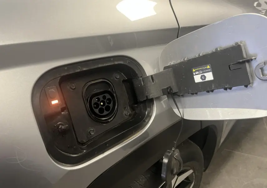 Prise de recharge ouverte côté gauche sur un Hyundai Tucson gris métallisé 2023 hybride rechargeable.