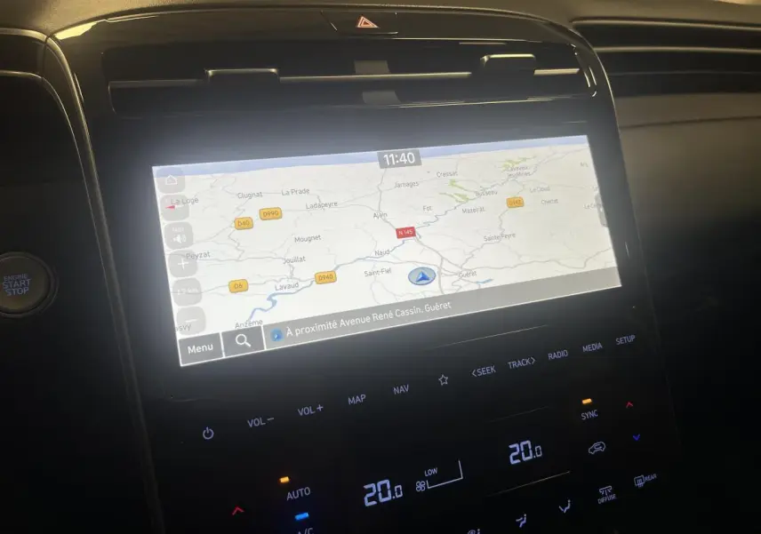 Vue rapprochée de l’écran tactile central du Hyundai Tucson 2023 affichant la navigation GPS et commandes climatisation.