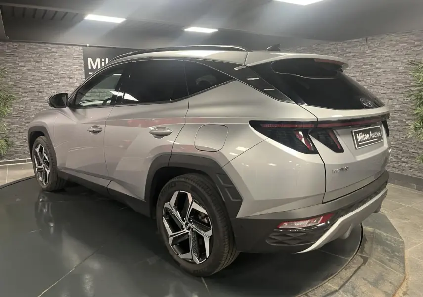 Vue 3/4 arrière droite du Hyundai Tucson gris métallisé avec jantes alliage 19 pouces et toit noir contrasté.